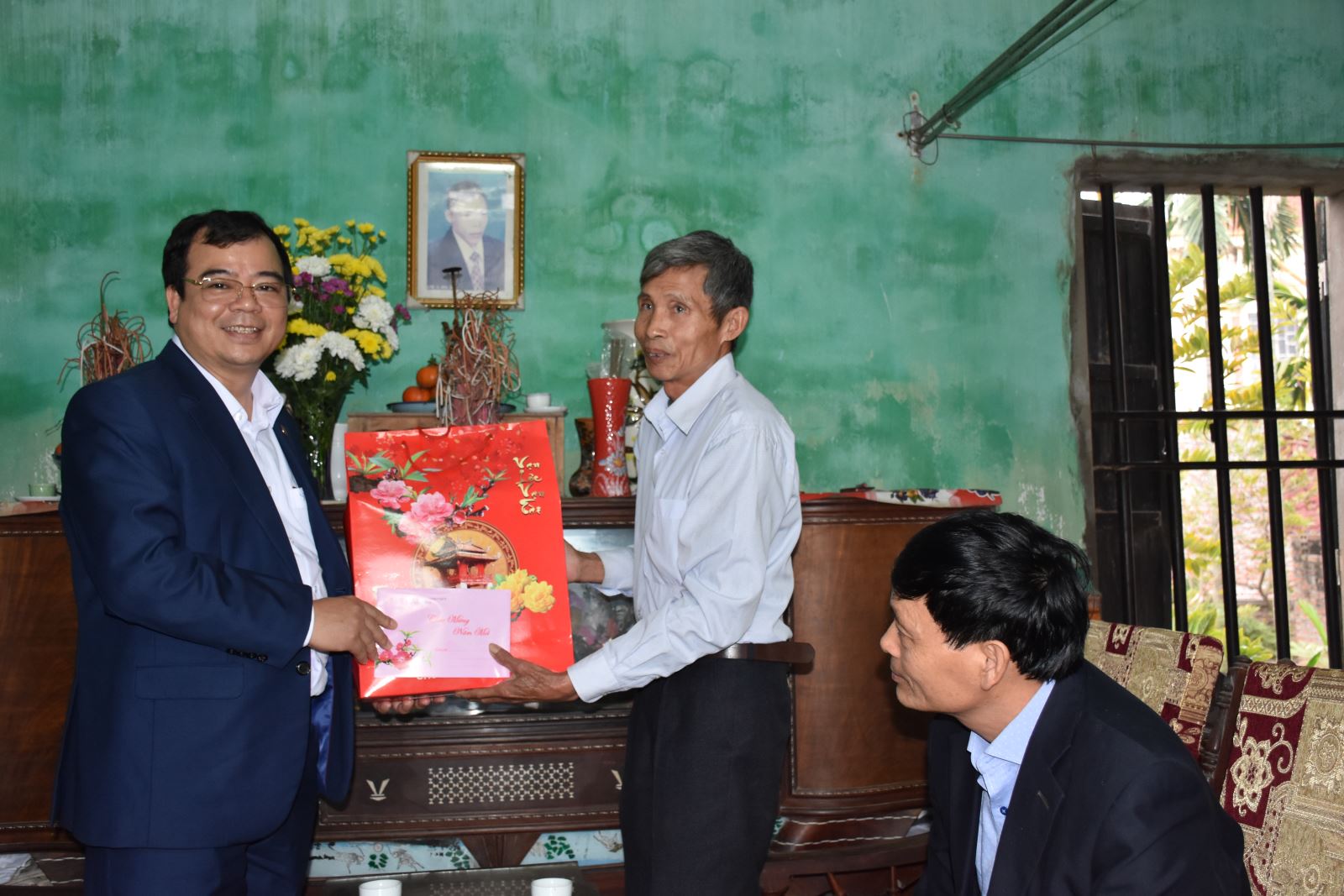 Đồng chí Nguyễn Minh Hùng - Bí thư Thị ủy, Chủ tịch HĐND thị xã Kinh Môn tặng quà cho ông Bùi Văn Chè bệnh binh 61% ở thôn Tống Long xã Thăng Long